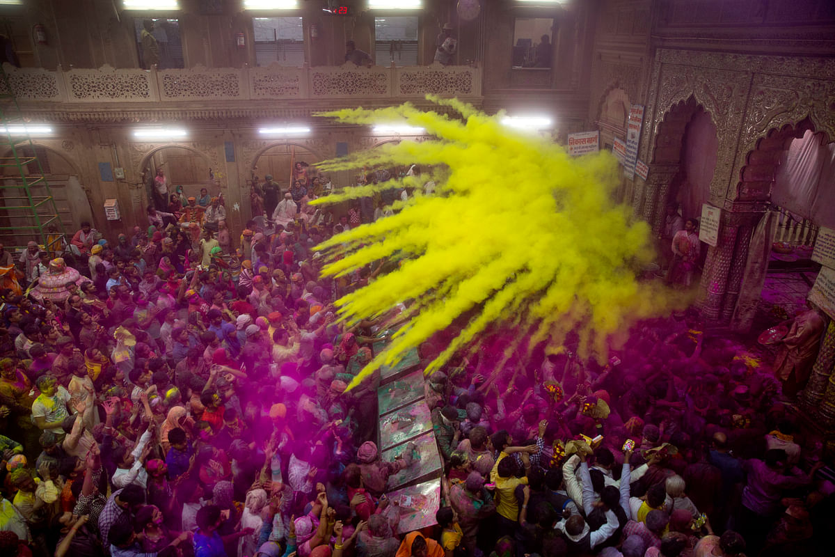 

Hindu devotees throw colored powder on each other inside Banke Bihari temple. (Photo: AP)