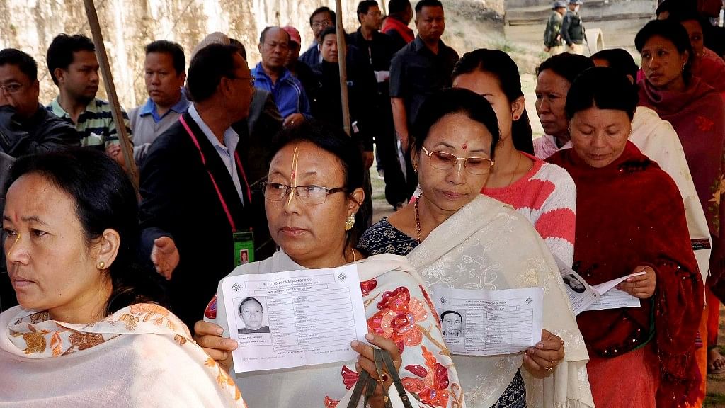 

Voters standing in queue show their identity cards during the first phase of the Manipur Assembly elections at Lilong in Imphal West on 4 March 2017. (Photo: PTI)