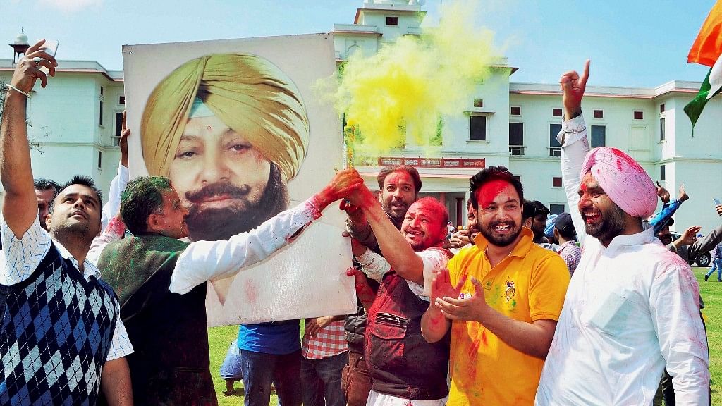 Congress workers celebrate the party’s win in Punjab outside PPCC President Capt Amarinder Singh’s residence in Patiala on Saturday. (Photo: PTI)