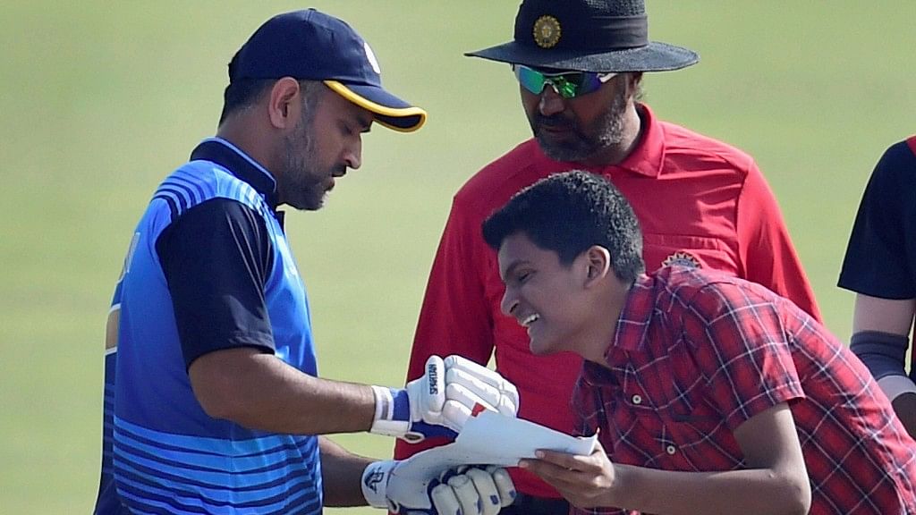Mahendra Singh Dhoni gives a fan his autograph while batting. (Photo: PTI)