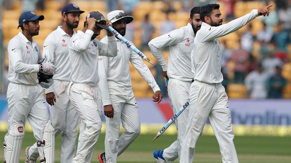 India’s captain Virat Kohli, right, leads his teammates off the field after their win over Australia in the second Test at Bangalore on Tuesday. (Photo: AP)