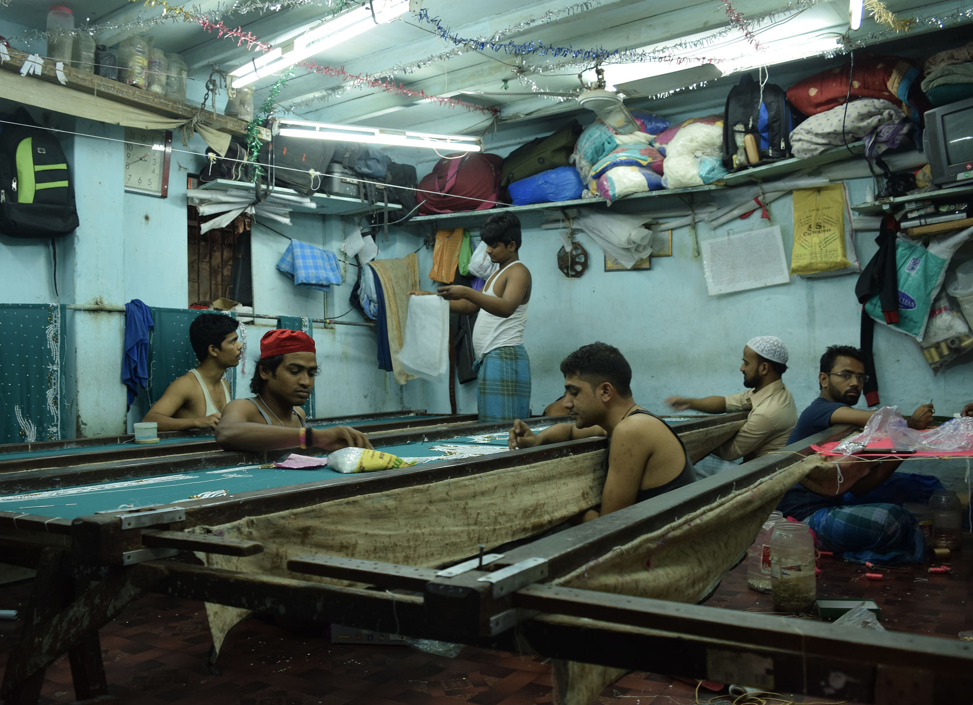 Workers embroider cloth is a small sweatshop in Dharavi. (Photo: Pallavi Prasad)