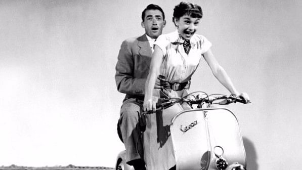 Gregory Peck with Audrey Hepburn in ‘Roman Holiday’. (Photo: <a href="http://www.lalibre.be/lifestyle/magazine/la-mythique-vespa-celebre-ses-70-ans-5719df2e35702a22d69f40c5">Screenshot</a>)