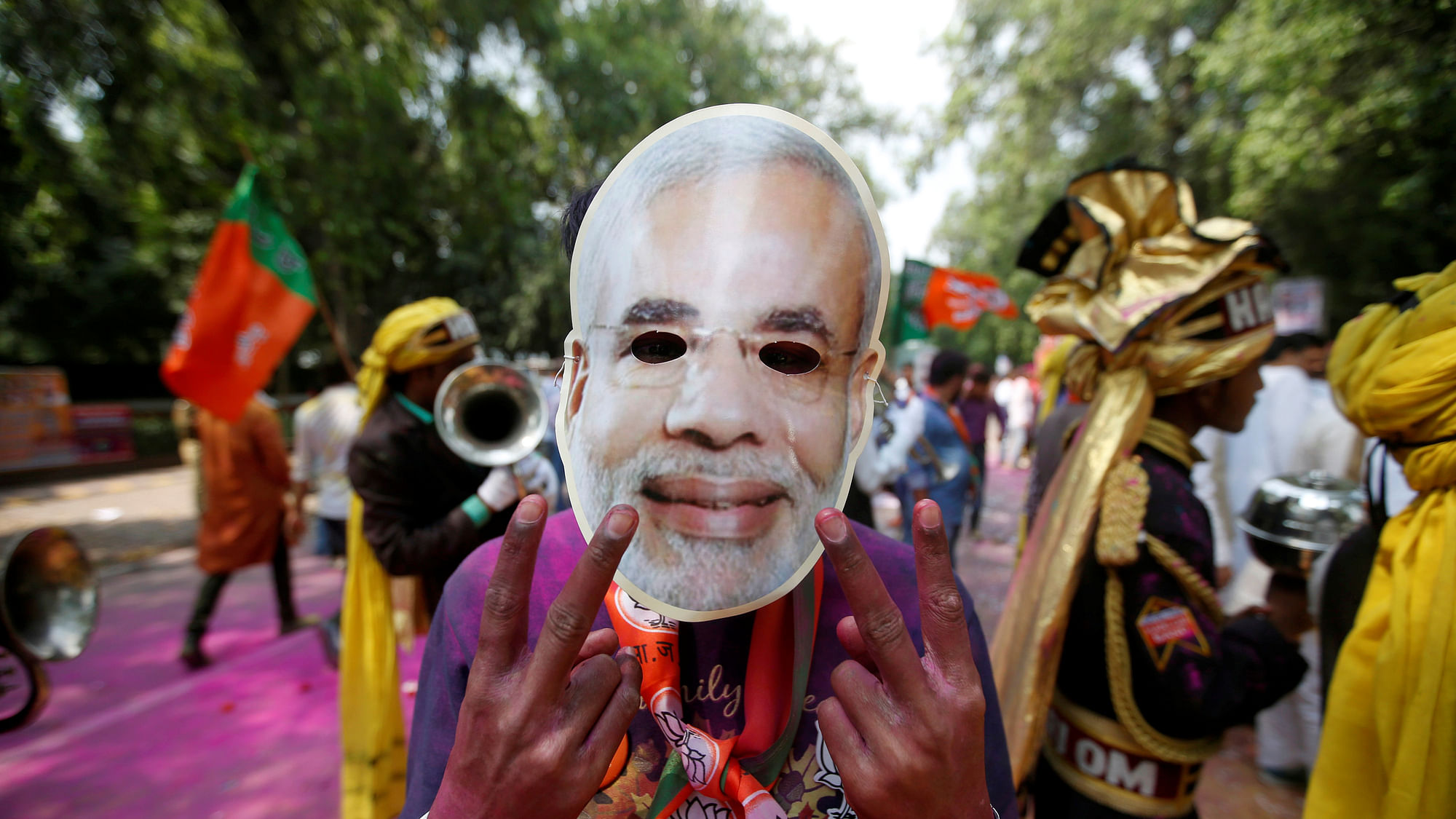 A supporter of Bharatiya Janata Party (BJP) celebrates after learning of the initial poll results outside the party headquarters in New Delhi on 11 March  2017. (Photo: Reuters)