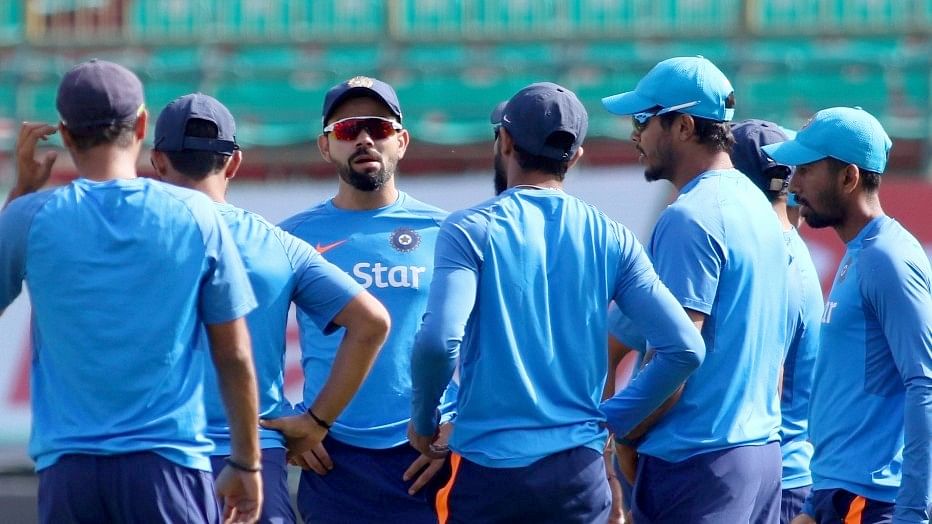 Virat Kohli chats with his team during a practice session. (Photo: IANS)