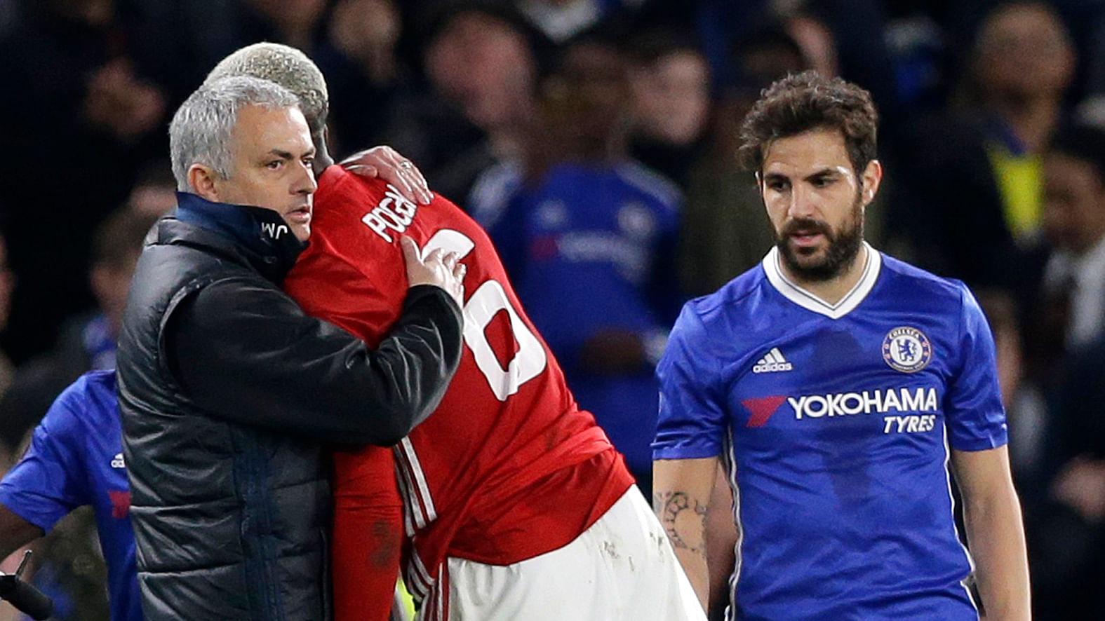 Manchester United’s manager Jose Mourinho embraces his player Paul Pogba as Chelsea’s Cesc Fabregas watches following their English FA Cup quarterfinal soccer match between Chelsea and Manchester United at Stamford Bridge. (Photo: AP)