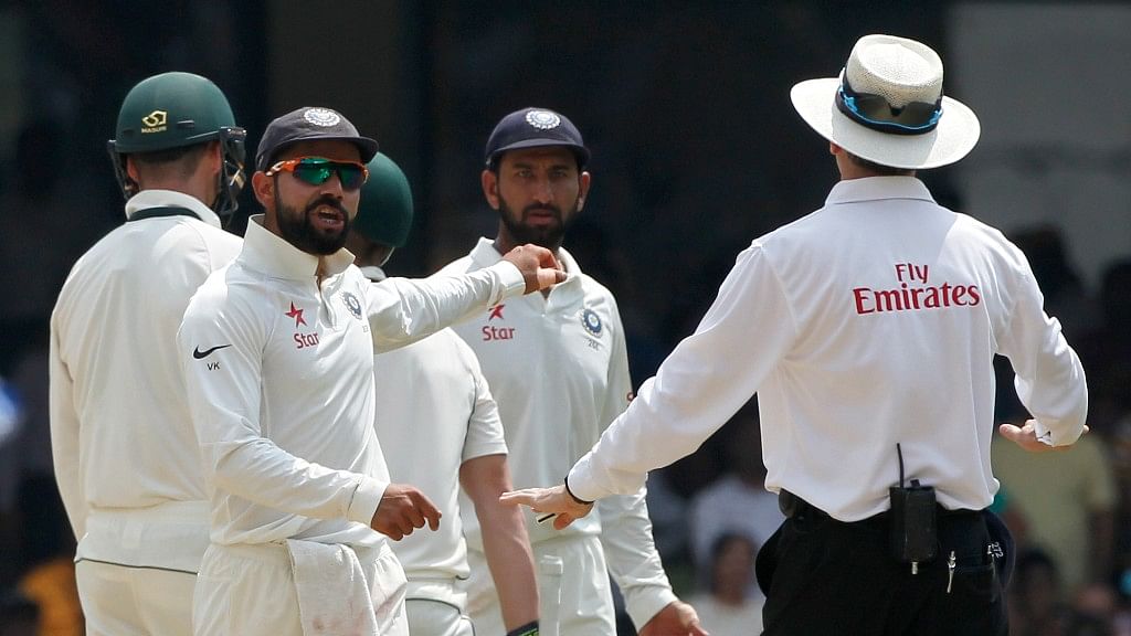 Virat Kohli speaks to the umpire after catching Steve Smith checking with the dressing room for a DRS appeal. (Photo: BCCI)
