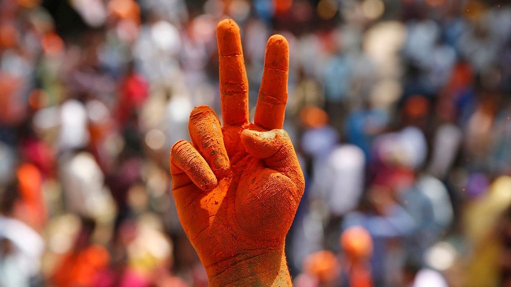 A BJP supporter’s hands covered in saffron as he celebrates the party’s win in Uttar Pradesh in Lucknow on 11 March, 2017. (Photo: AP)