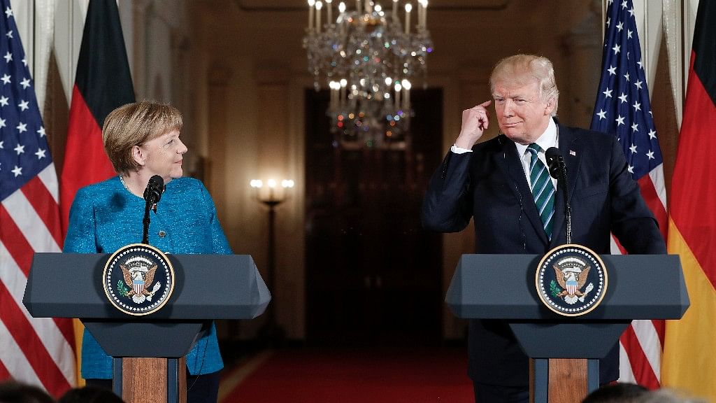 US President Donald Trump points to his ear piece as he waits to listen for the translation while participating in the joint news conference with German Chancellor Angela Merkel. (Photo: AP)