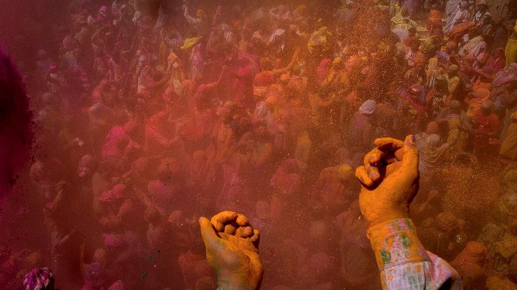 Locals and Hindu widows throw flower petals and colored powder during Holi celebrations at the Gopinath temple in Vrindavan. (Photo: AP)