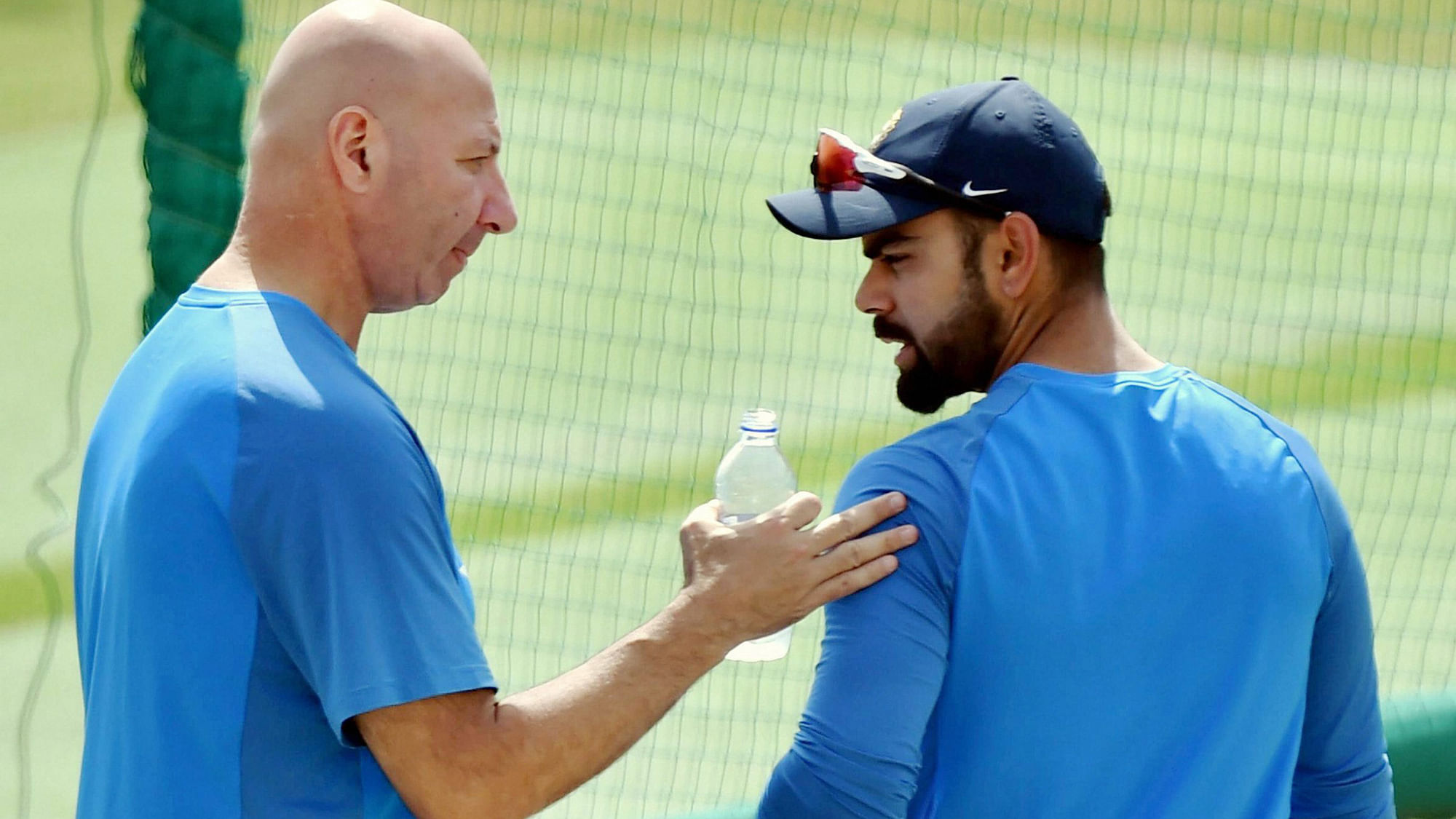 Dharamsala: Indian cricket captain Virat Kolhi with team’s physiotherapist Patrick Farhart during a practice session on the eve of the last test match against Australia. (Photo: PTI)