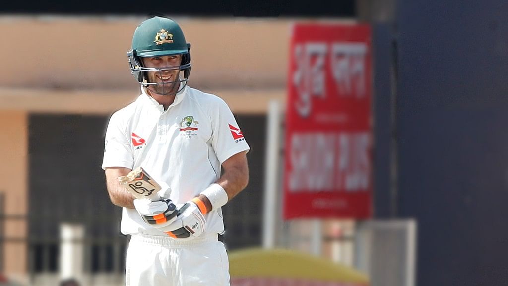 Glenn Maxwell smiles after losing the bottom half of his bat. (Photo: BCCI)