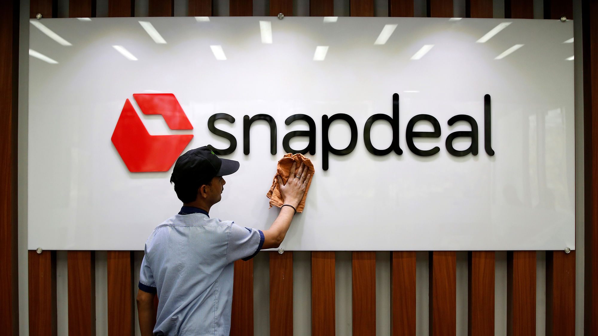An employee cleans a Snapdeal logo at its headquarters in Gurugram. (Photo: Reuters)