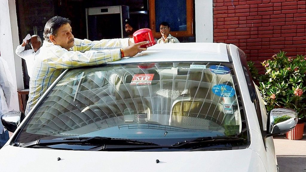 Sports Minister Vijay Goel’s driver removes the red beacon from the minister’s car in New Delhi on Wednesday. (Photo: PTI)
