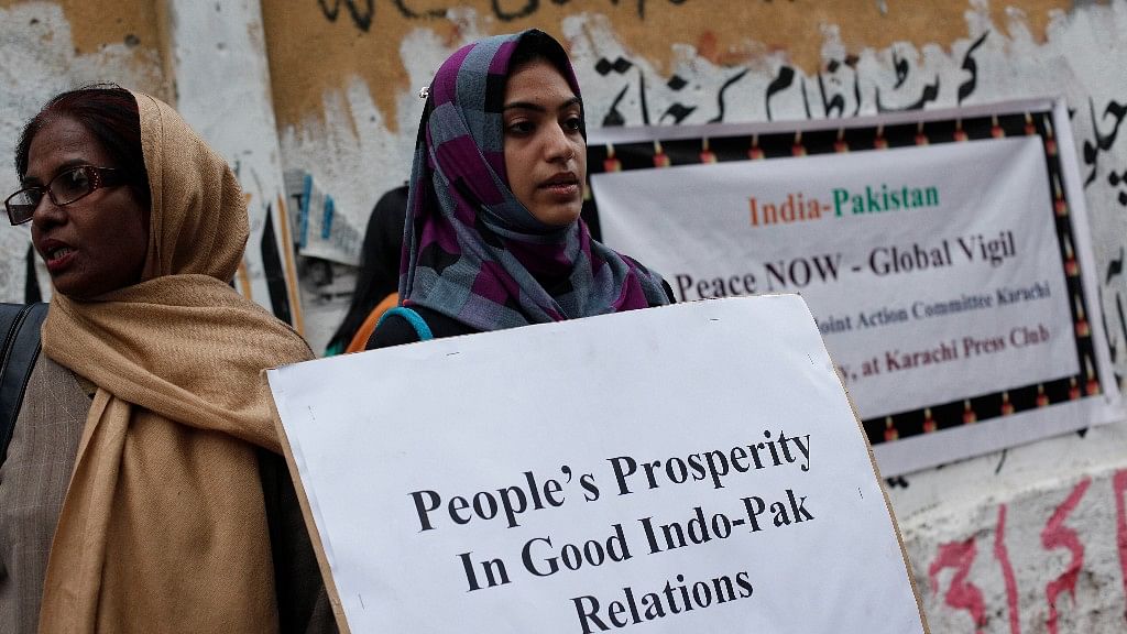 File image of a member of Joint Action Committee (JAC), an alliance of civil society organisations, holds a placard while observing the global vigil for peace between India and Pakistan, in Karachi on 27 January 2013. (Photo: Reuters)