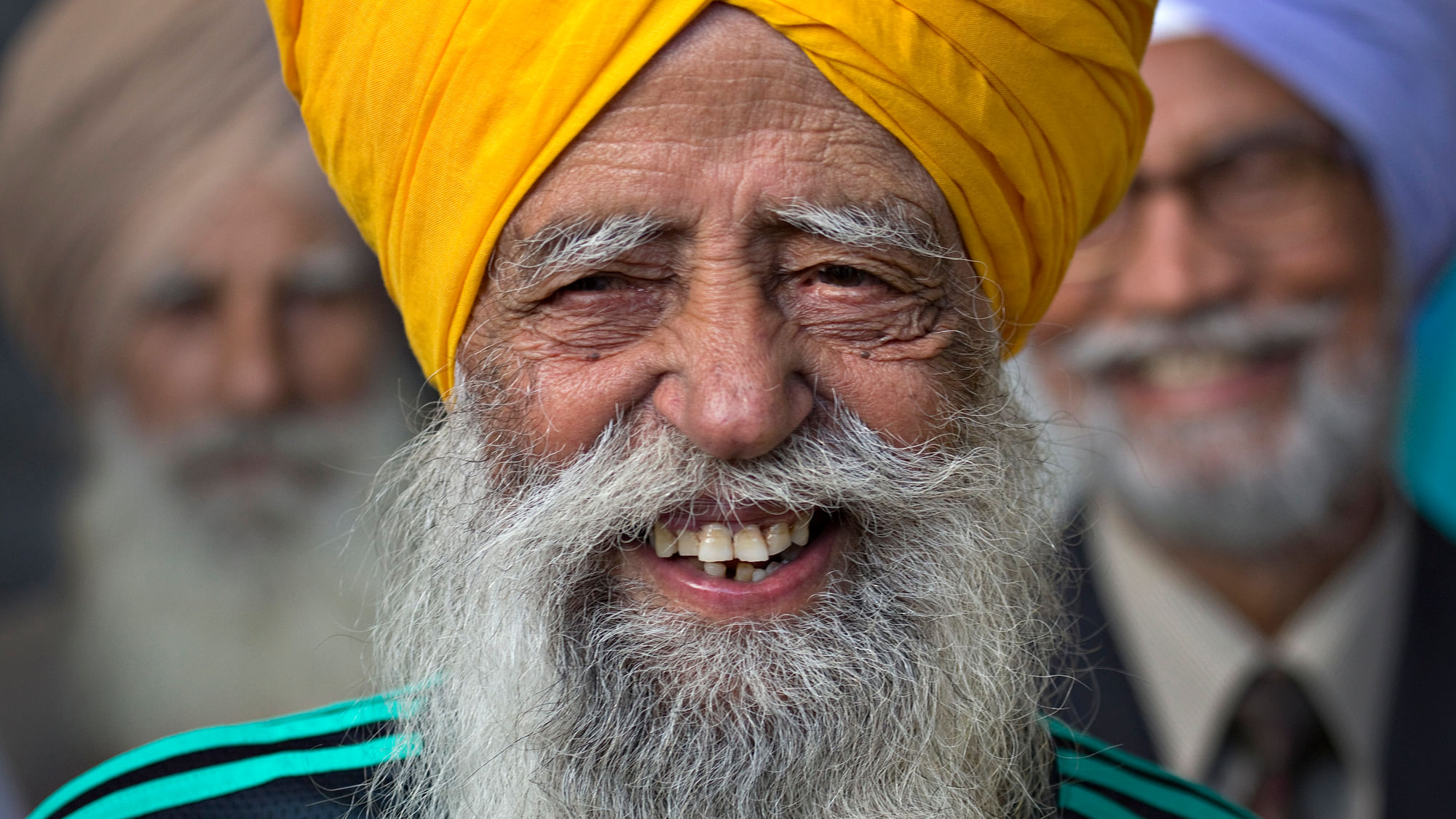  Fauja Singh is all smiles before taking part in the inaugural Surrey World Music Marathon in 2012. (Photo: Reuters)