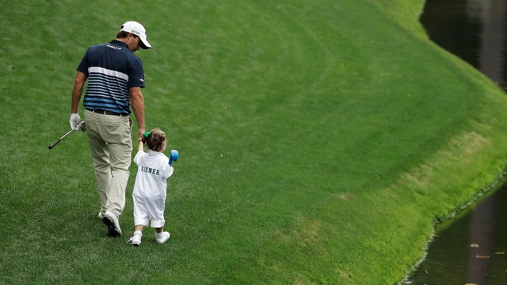 Kevin Kisner and daughter Kate walk up the fourth hole during the par three competition at the Masters golf tournament. (Photo: AP)