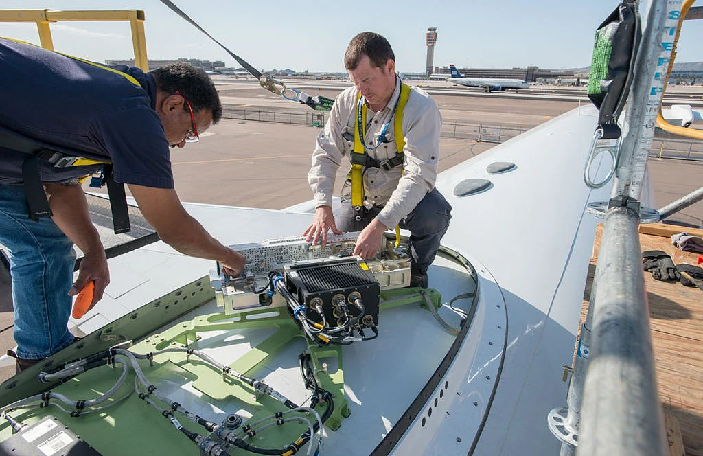 Engineers fitting in-flight Wi-Fi router on a test Boeing B757 plane. (Photo Courtesy: Honeywell Aerospace)