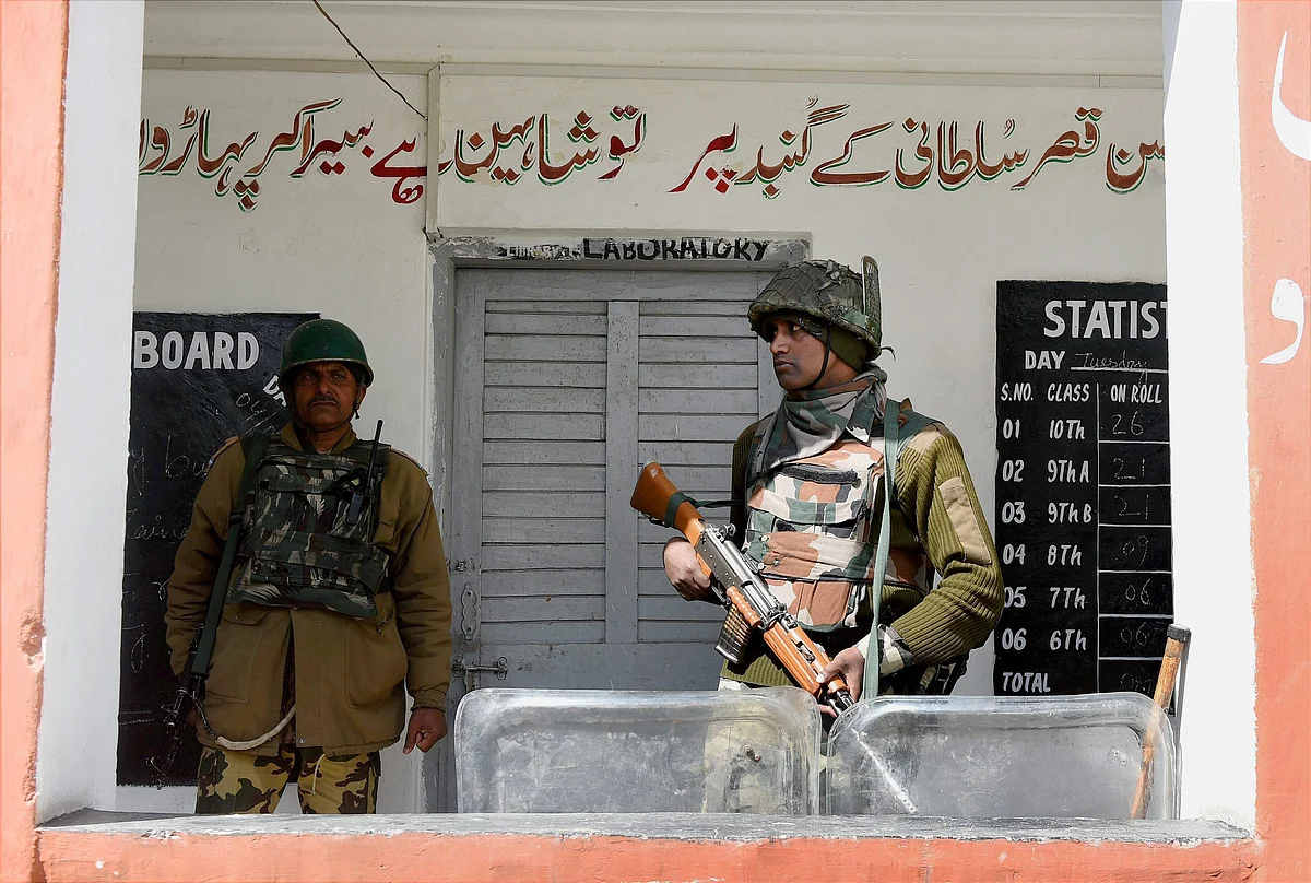 A jawan stand guard outside a polling station for Srinagar Parliamentary constituency of Jammu and Kashmir at Budgam in Srinagar on Sunday. (Photo: PTI)
