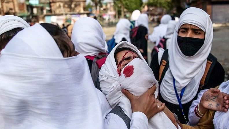 Kashmiri schoolgirls tend to a wounded girl after she was hit by a stone during a protest in Srinagar, Indian controlled Kashmir on 20 April 2017. (Photo: AP)