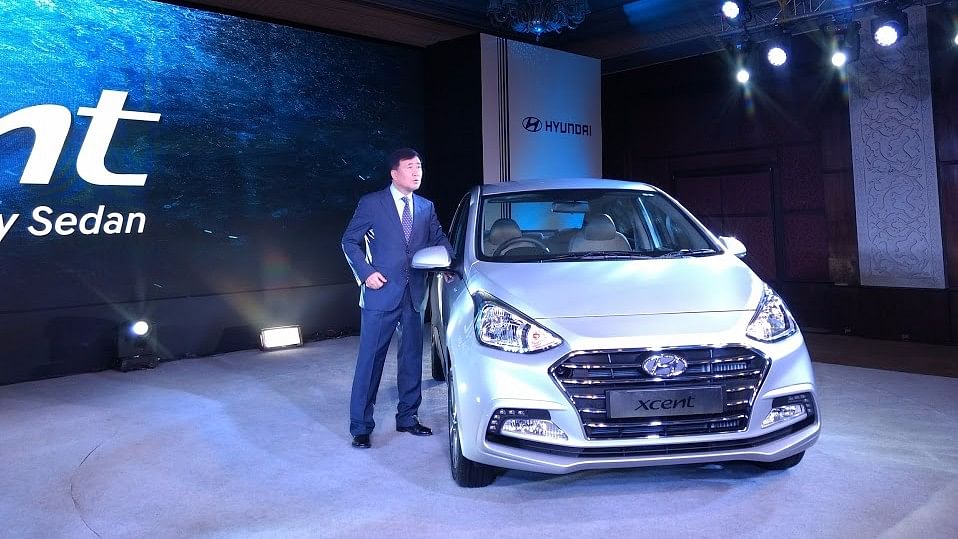 Hyundai MD &amp; CEO YK Koo with the new Xcent. (Photo: <b>The Quint</b>)