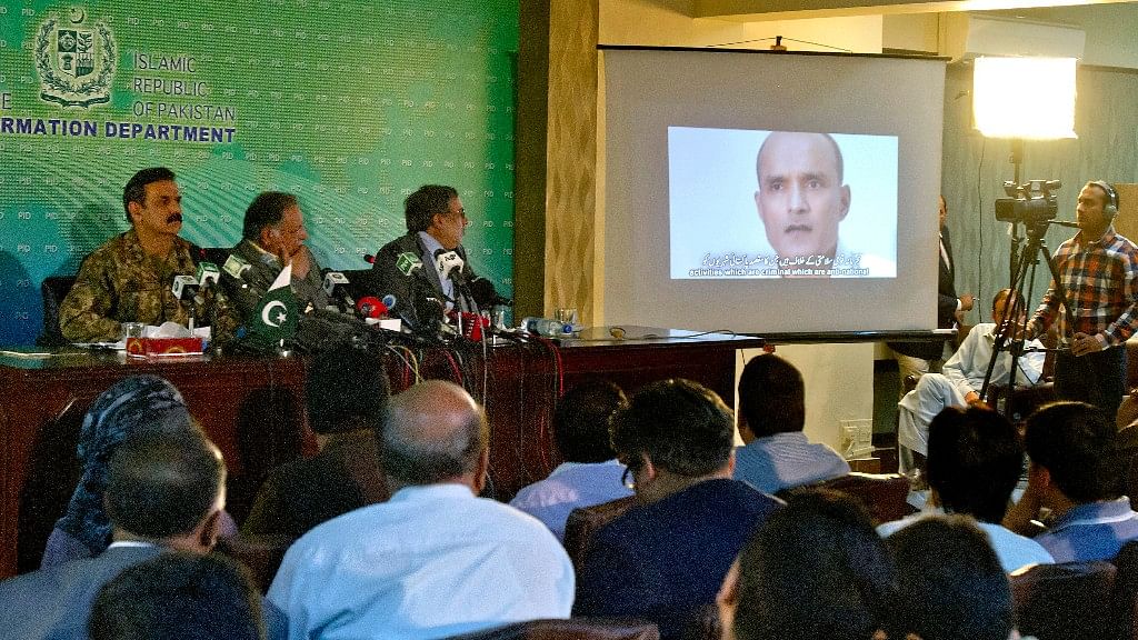 

In this 29 March 2016 photo, journalists look a image of Indian naval officer Kulbhushan Jadhav, who was arrested in March 2016. (Photo: AP)