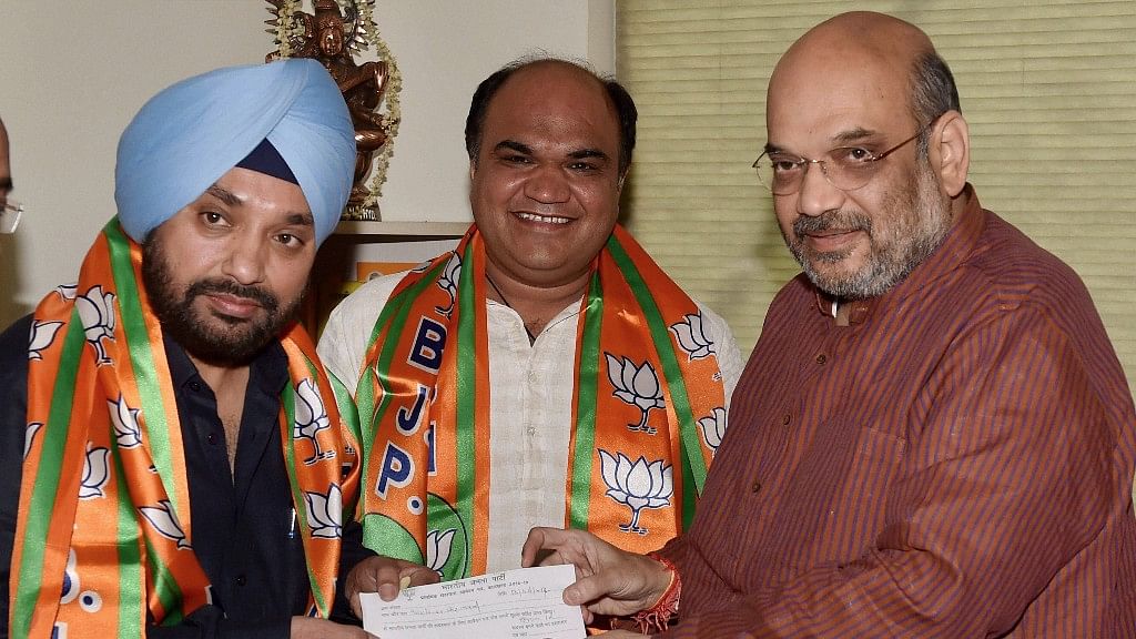 BJP President Amit Shah presents the party membership slip to former DPCC President Arvinder Singh Lovely as he joins Bharatiya Janata Party  (Photo: PTI)