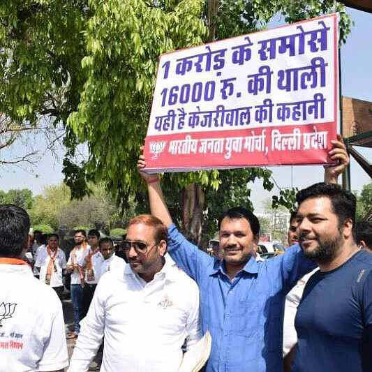 BJP volunteers hold placards criticising Kejriwal govt for spending Rs 1 crore on snacks, as revealed in an RTI query. (Photo Courtesy: <a href="https://www.facebook.com/pg/BJP4Delhi/photos/?ref=page_internal">BJP Delhi</a>/ Facebook)