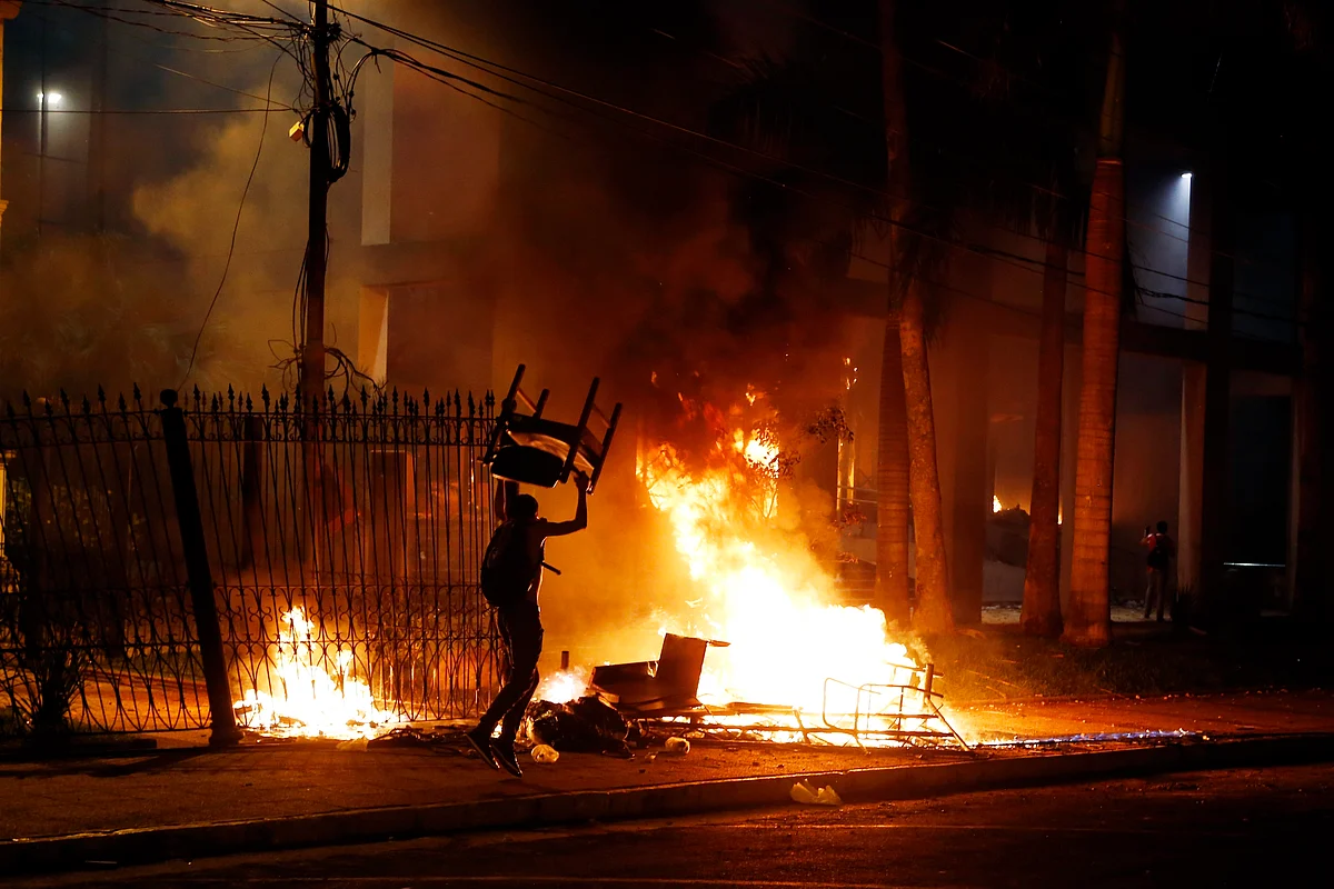 A protester carries a chair to a fire outside the congress building during clashes between police and protesters. Some protesters broke through police lines and entered the first floor, where they set fire to papers and furniture. (Photo: AP)