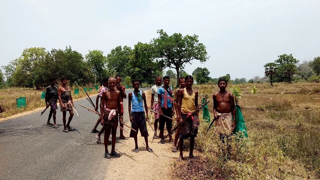 A group of men from Malkangiri clutch bows and arrows as they leave for a hunting trip. (Photo: Chandan Nandy/<b>The Quint</b>)