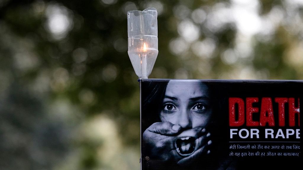 A candle is seen on a placard during a protest in New Delhi on 29 December 2012. (Photo: Reuters)&nbsp;
