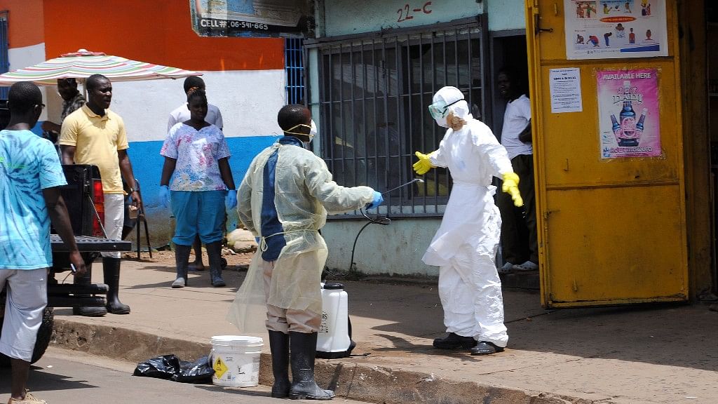 File Photo: Member of a burial team sprays a colleague with chlorine disinfectant in Monrovia, the capital of Liberia 20 October 2014. (Photo: Reuters)