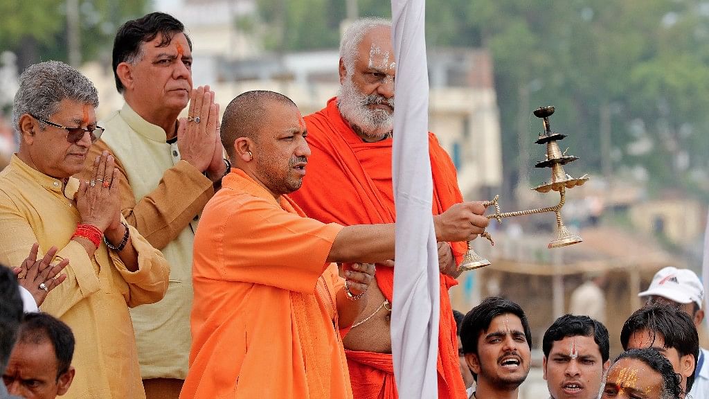 Uttar Pradesh Chief Minister Yogi Adityanath holds a traditional lamp as he performs an “aarti” on the banks of river Sarayu in Ayodhya. (Photo: Reuters)