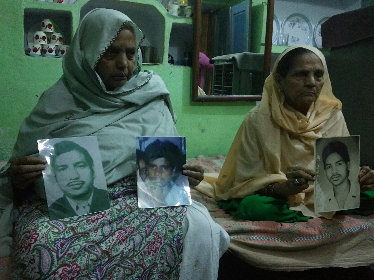 Zareena and Hajra holding pictures of their family members killed in the massacre. (Photo Courtesy: Mahtab Alam)