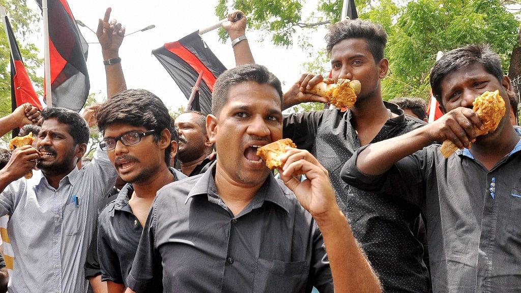 Members of various organisations, including some political outfits, eat beef during a demonstration in front of Indian Institute of Technology, Madras condemning the attack on a student for conducting beef festival in Chennai on Wednesday. (Photo: PTI)&nbsp;