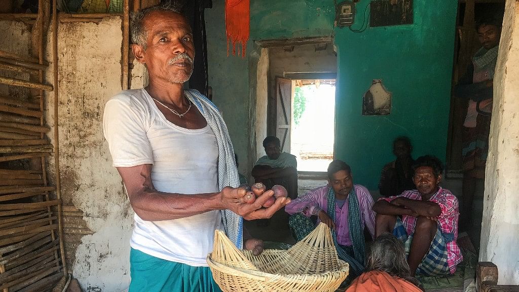 Farmer Rajesh Singh shows a basket of forest produce in Chhattisgarh’s Sonakhan village, which may soon be enveloped by the country’s first private gold mine. (Photo: Thomson Reuters Foundation/Rina Chandran)