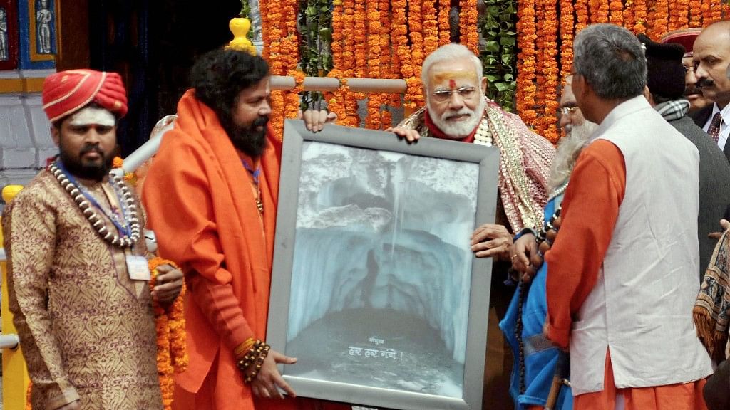 The Shri Kedarnath Temples Committee presents Narendra Modi with a picture of Gomukh at the Kedarnath Temple, which was reopened after a six-month-long break, in Rudraprayag on Wednesday. (Photo: PTI)
