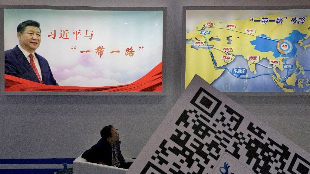 An attendee at a conference looks up near a portrait of Chinese President Xi Jinping with the words “Xi Jinping and One Belt One Road” and “One Belt One Road strategy,” in Beijing on 28 April 2017. (Photo: AP)