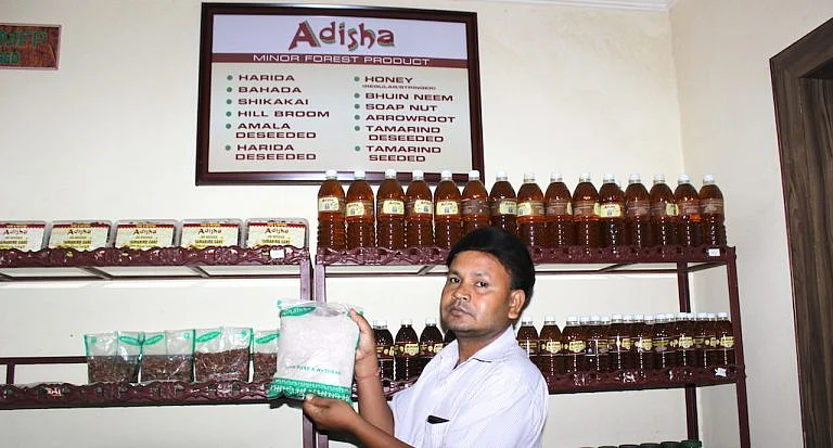 At a Bhubaneswar government outlet for minor forest products, a shop assistant holds up their fastest moving item, the powdered millet packet, whose sale has doubled in the last year. 