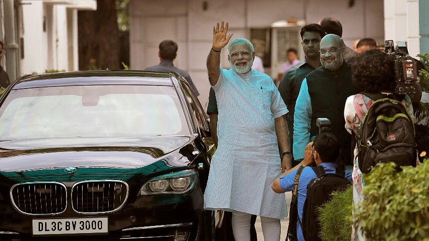 Indian Prime Minister Narendra Modi, second right, greets media, along with Bharatiya Janata Party president Amit Shah. (Photo: AP)