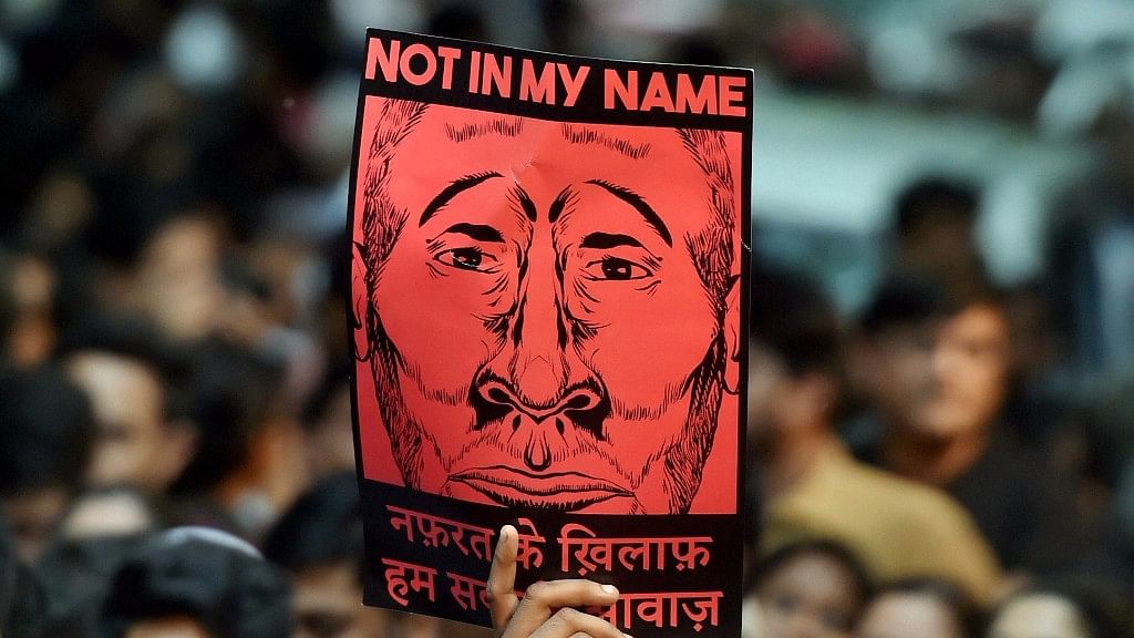 A participant shows a placard during a silent protest “Not in My Name” against the targeted lynching at Jantar Mantar in New Delhi