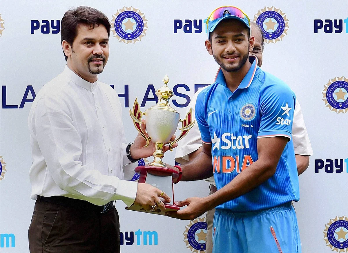 BCCI Secretary Anurag Thakur hands over the winning trophy to India ‘A’ Skipper Unmukt Chand after they won the 3rd ODI series against Bangladesh ‘A’ in July 2016. (Photo: PTI)