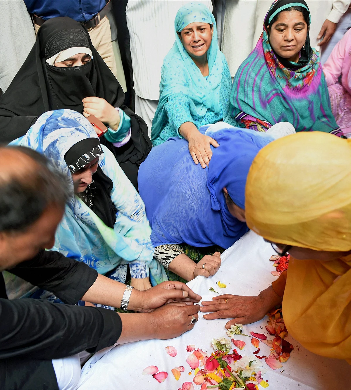 Pandith’s family members grieving his death on 23 June, after his funeral ceremony. 