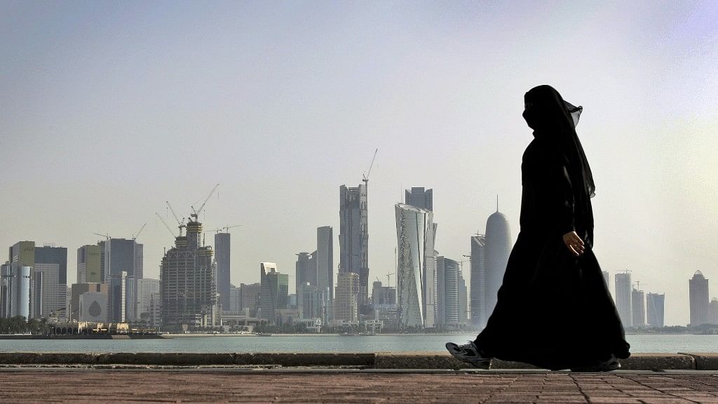 A file image of a Qatari woman walking in front of the city skyline in Doha. (Photo: AP)