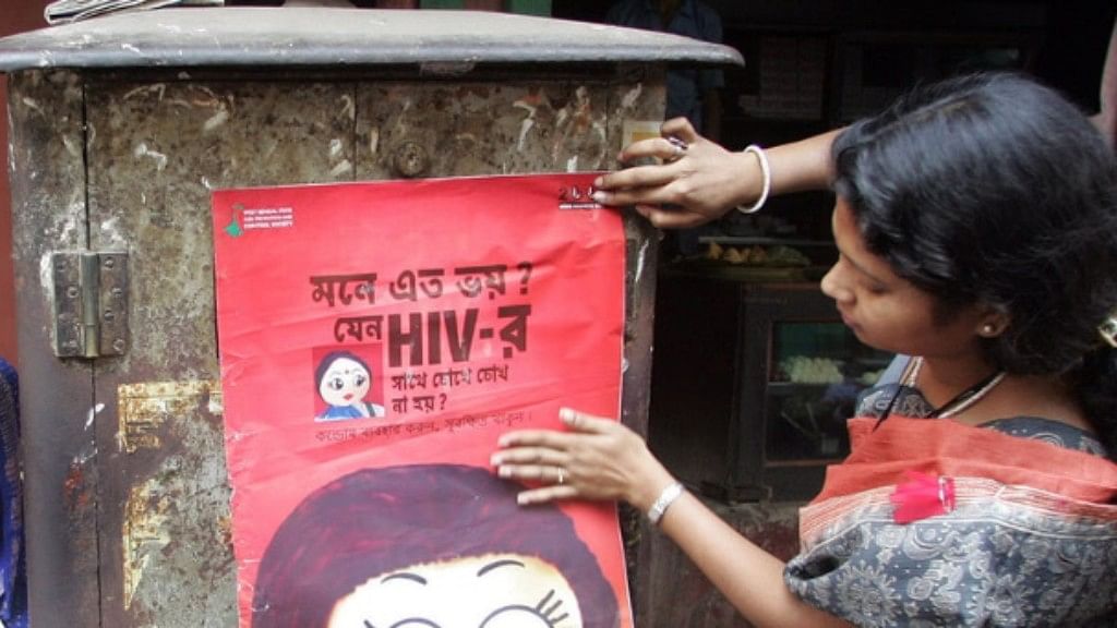 An activist puts up a poster during an AIDS awareness drive in Sonagachi.&nbsp;