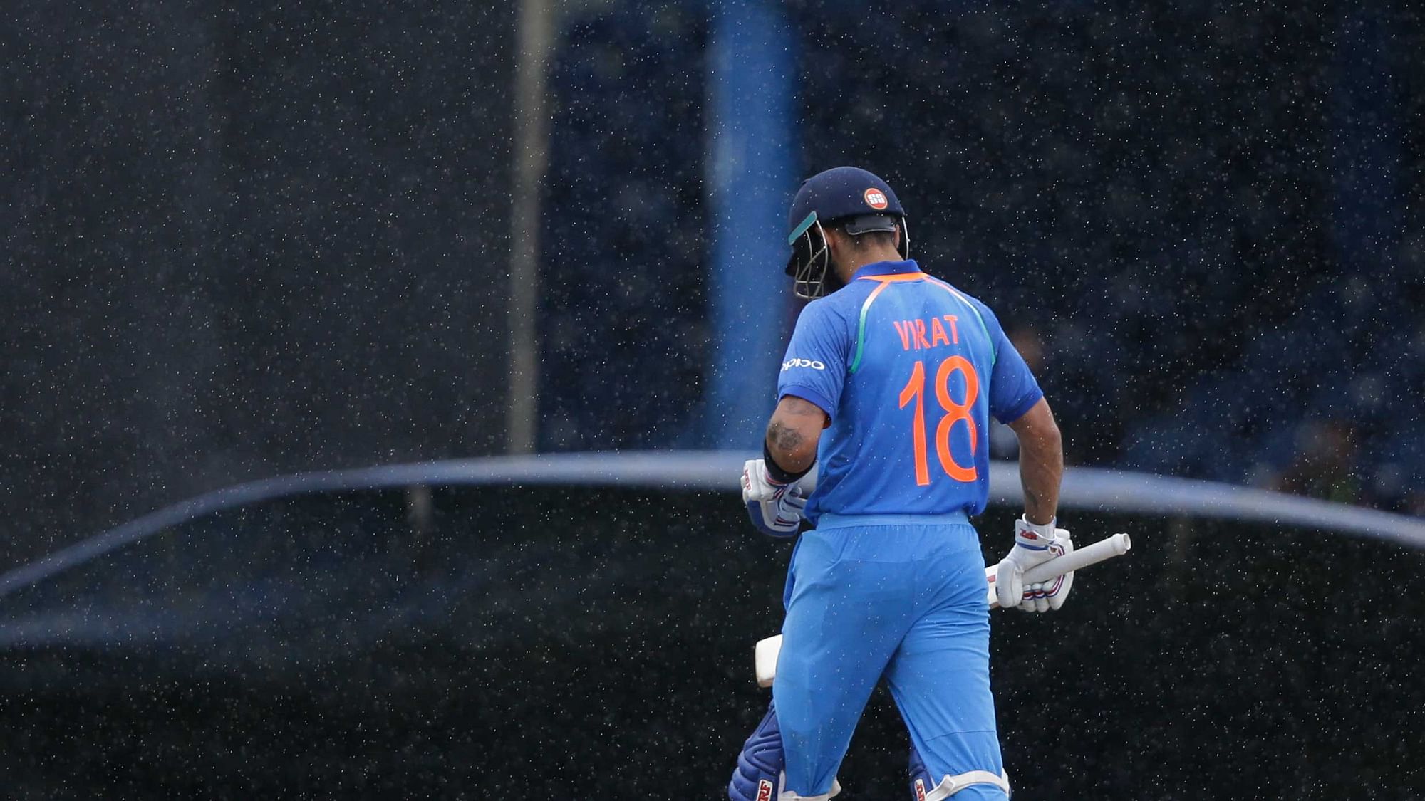 India’s captain Virat Kohli leaves the field as rain delay play for the second time during the first ODI cricket match against West Indies at Queen’s Park Oval. (Photo: AP)