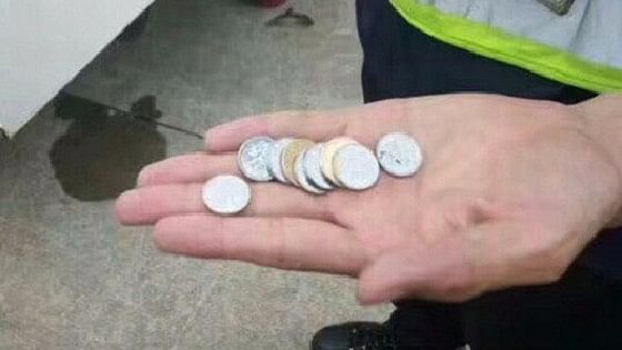 Chinese Police shows the coins retrieved from the plane engine