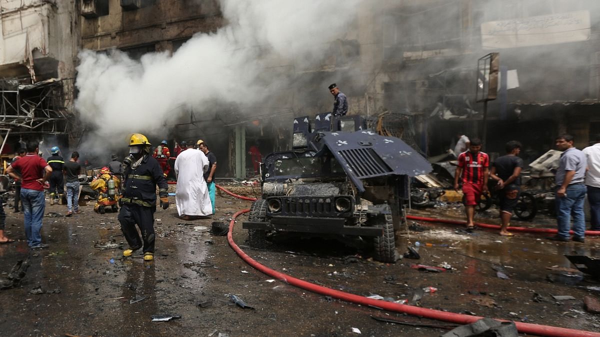  Security officials and civilians gather around an earlier car bomb site in June. Image used for representational purposes. (Photo: AP)