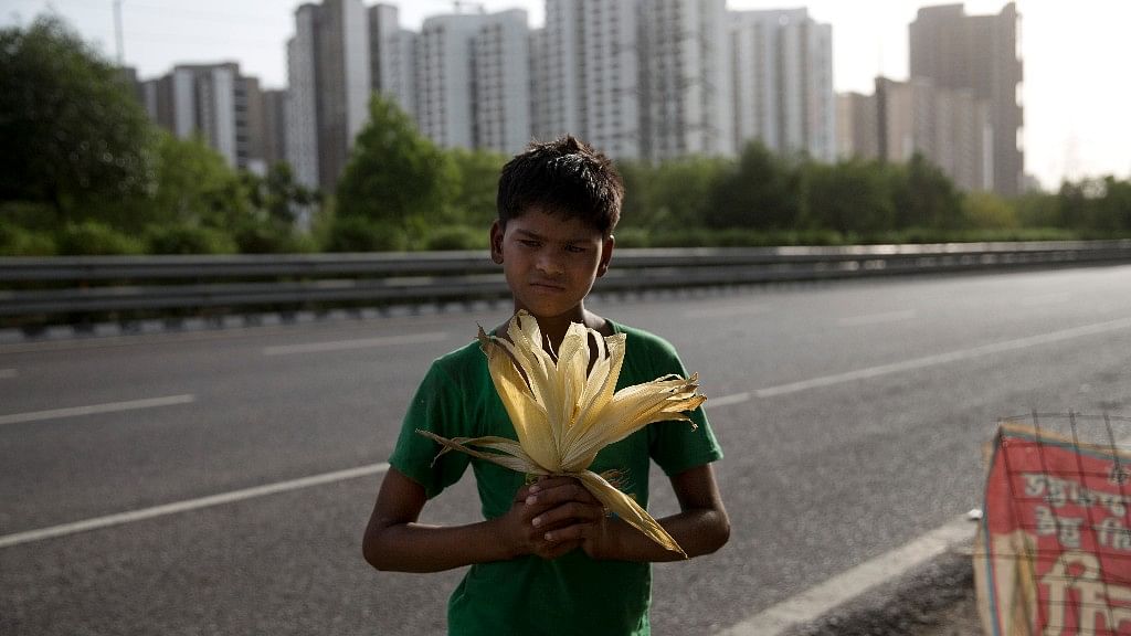 Vikas, 12, a boy who sells cooked corn along a busy expressway, poses for a photo in Noida. Every 100 metres or so on the busy Noida expressway, you’ll find a child selling corn. (AP Photo/Tsering Topgyal)