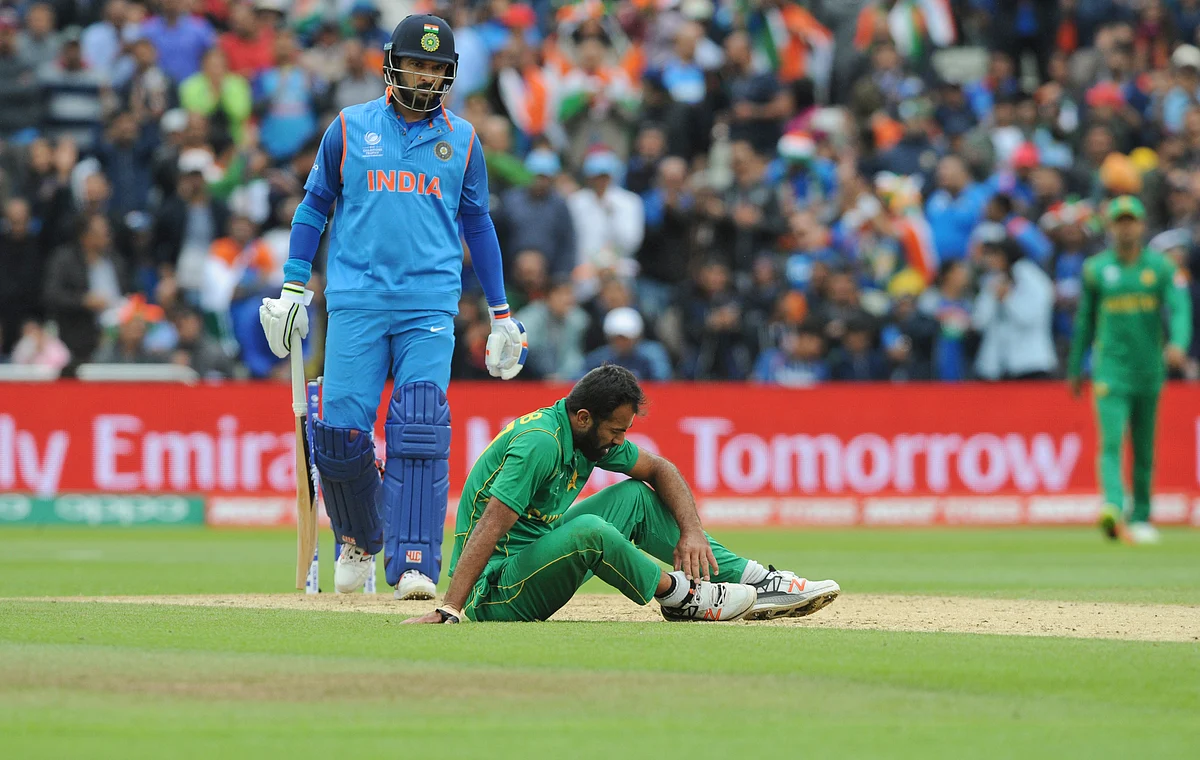 Pakistan’s Wahab Riaz sits on the field holding his ankle after an injury during the ICC Champions Trophy match between India and Pakistan. (Photo: AP)